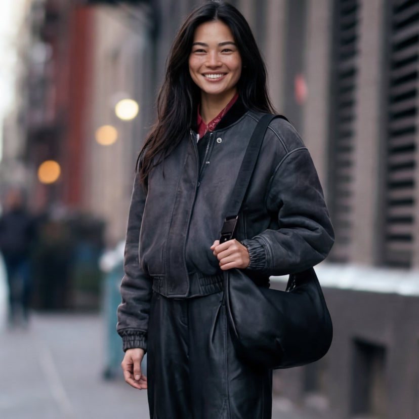 Woman standing on sidewalk in paris carrying the Lo & Sons Aoyama crossbody bag