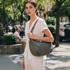 woman on sidewalk outside holding green Aoyama 2 in leather