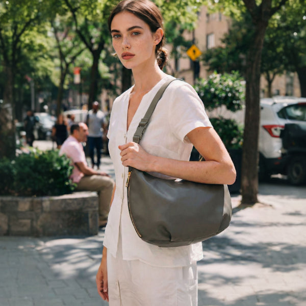 woman on sidewalk outside holding green Aoyama 2 in leather