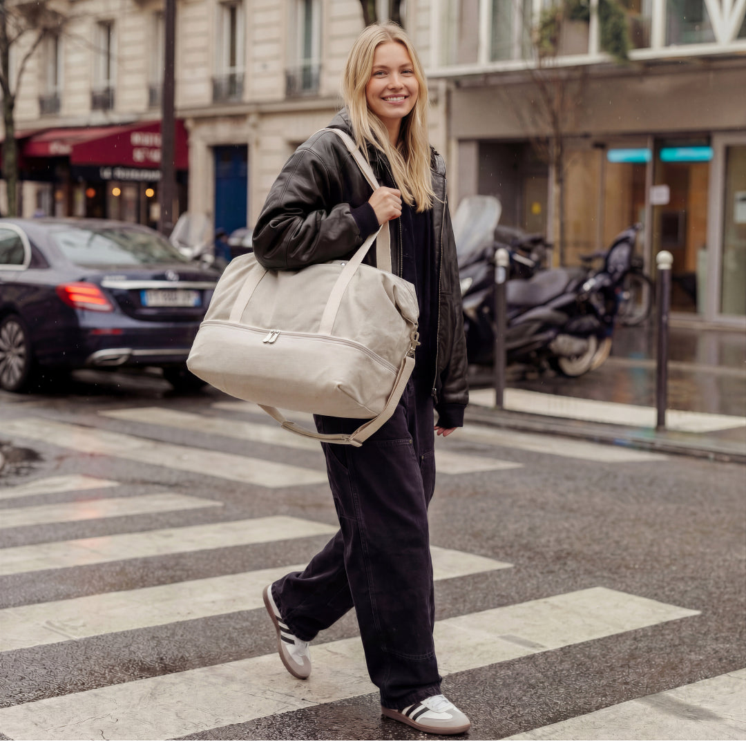 Woman crossing a street with a Catalina Deluxe bag in Dove Grey in an urban setting