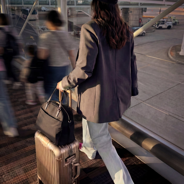Woman walking through an airport carrying The O.G. 2 on a suitcase