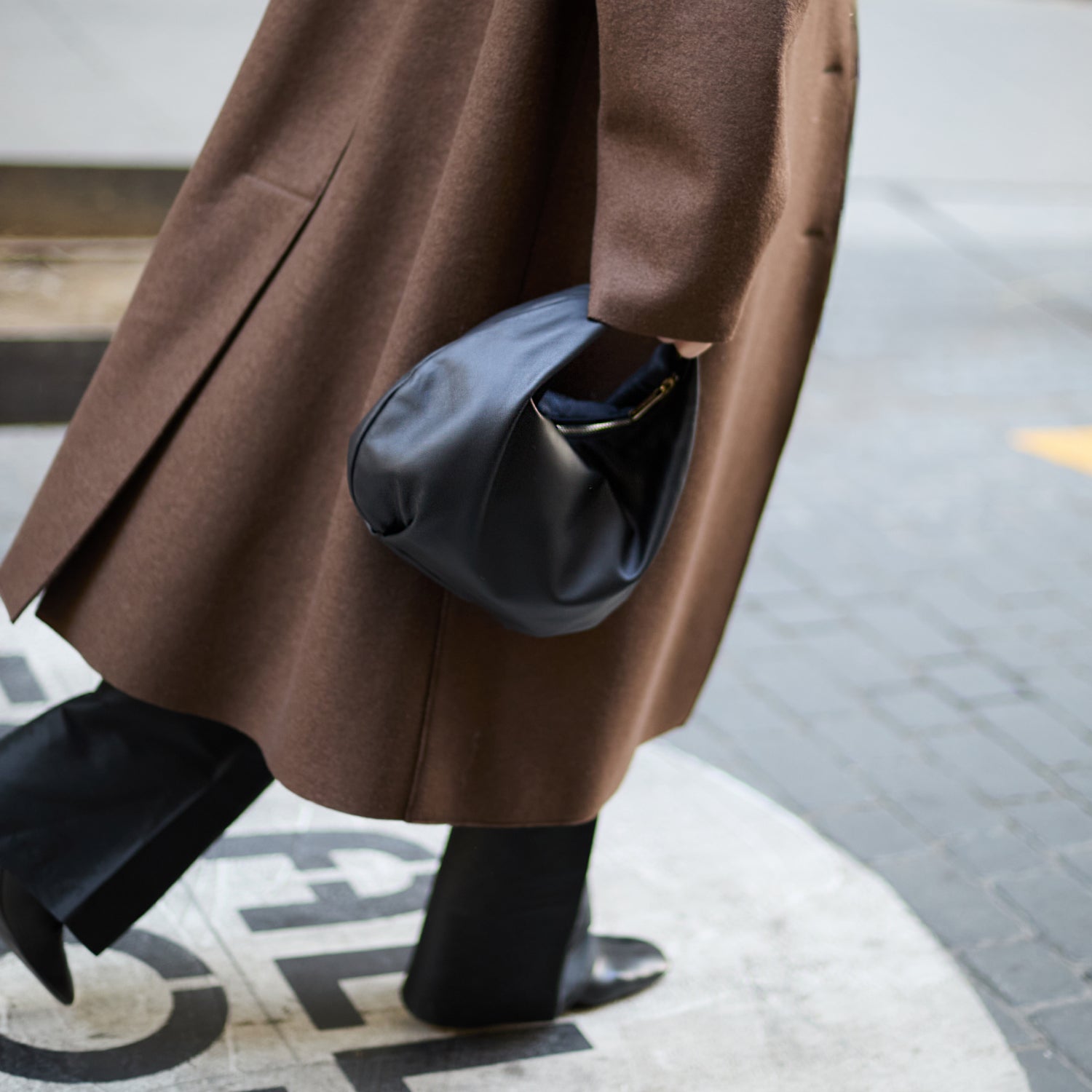 closeup of woman holding the Aoyama 2 in black leather as a large clutch