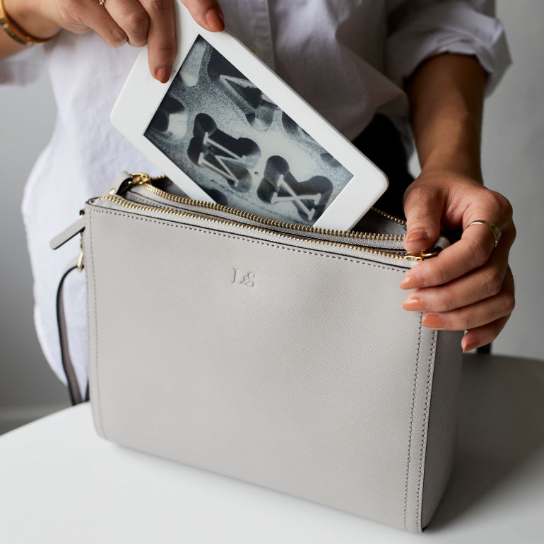 padded mini tablet pocket of the Lo & Sons Pearl crossbody bag in light grey saffiano