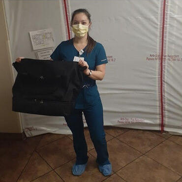 Female medical professional with Lo & Sons Catalina Deluxe bag at a hospital during the COVID-19 pandemic
