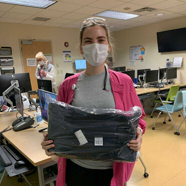 Female medical professional with Lo & Sons Catalina Deluxe bag at a hospital during the COVID-19 pandemic