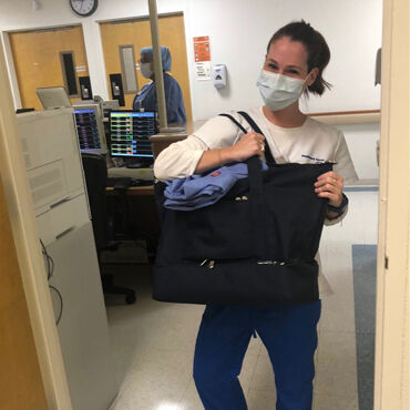 Female medical professional with Lo & Sons Catalina Deluxe bag at a hospital during the COVID-19 pandemic