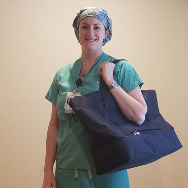 Female medical professional with Lo & Sons Catalina Deluxe bag going to a hospital during the COVID-19 pandemic